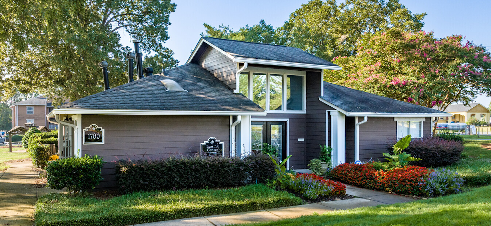 Exterior view of a multifamily residential property with landscaped grounds and leasing office.